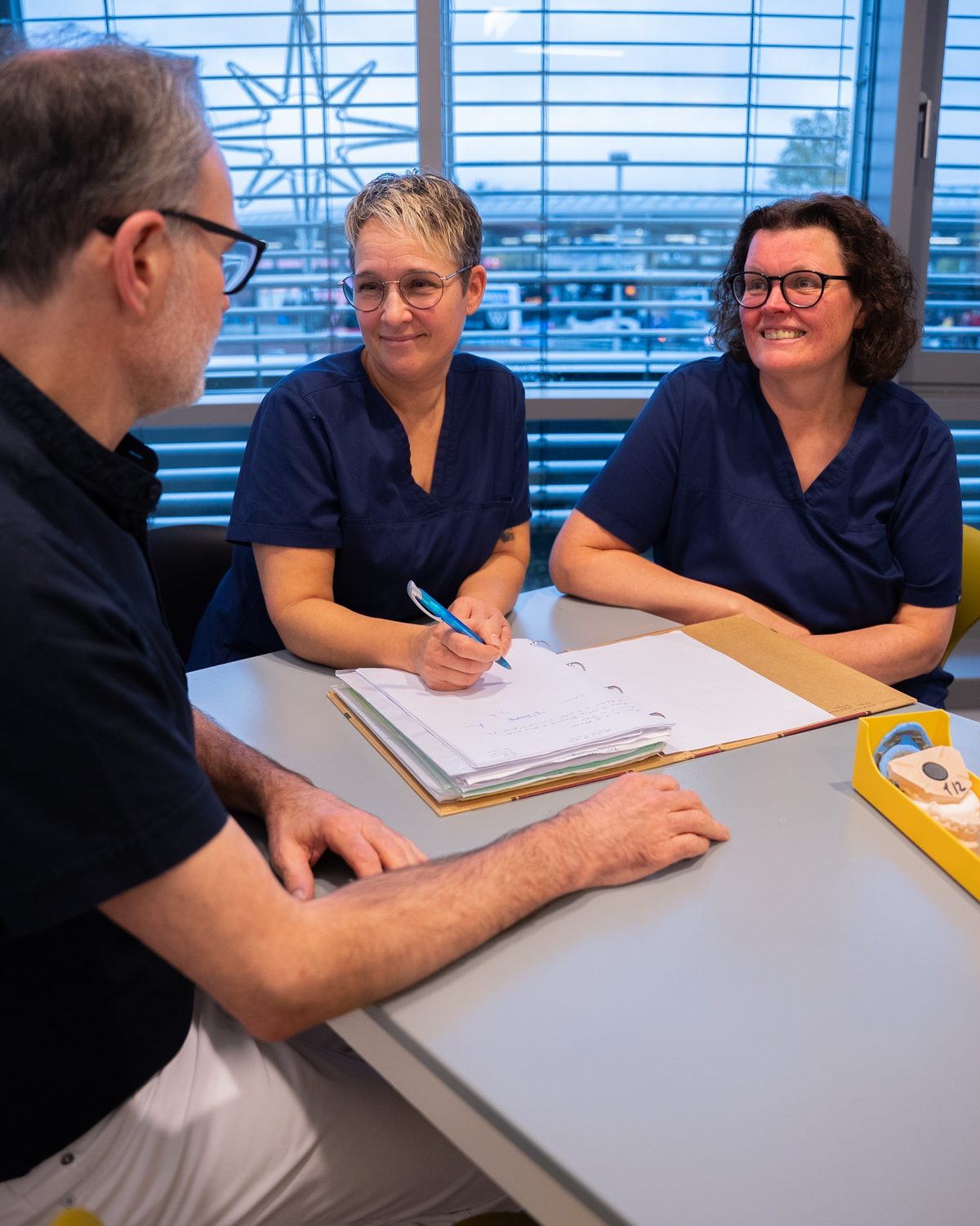 Dr. Vogel im Gespräch mit zwei Kolleginnen am Besprechungstisch